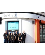 A group of people stood outside of a building. The sign on the building reads "One Wirral CIC"