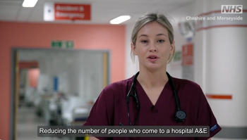 A still from the video. A nurse in her uniform. Text reads "reducing the number of people who come to a hospital A&E"
