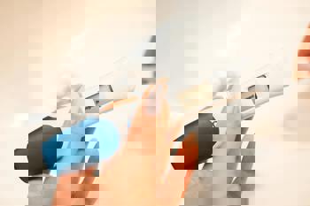 A hand holding a digital pregnancy test showing "Pregnant" on the display. 