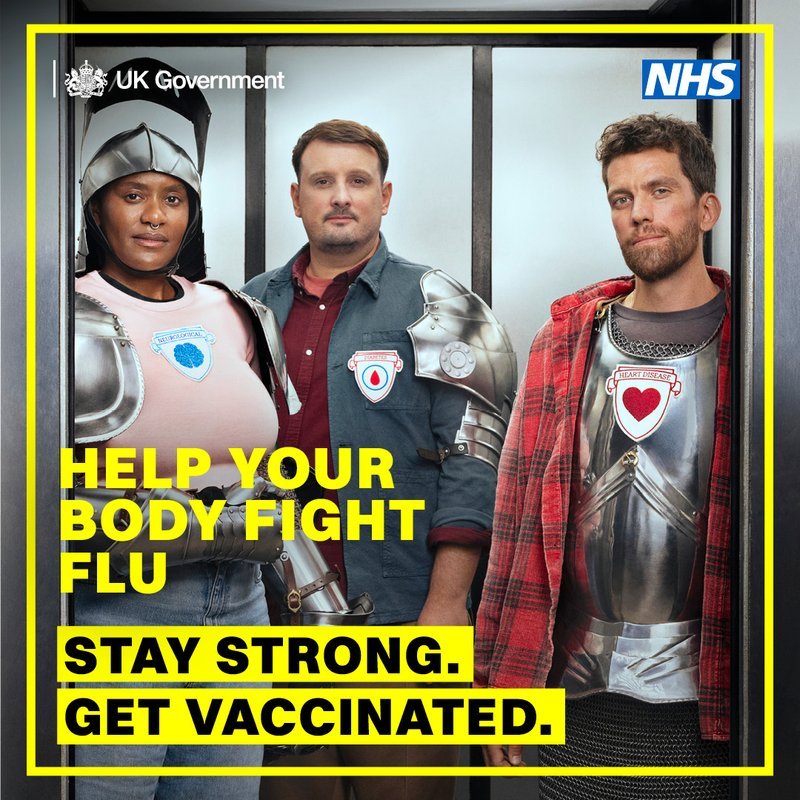 Three people wear medieval armor and casual clothes, symbolizing protection. UK Government and NHS logos are visible. Text: "Help your body fight flu. Stay strong. Get vaccinated."
